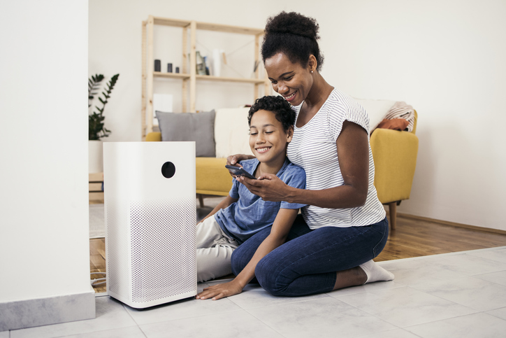 African American woman and her son adjusting air purifier using a smart system