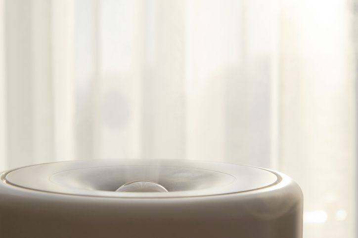 Electric humidifier with steam opposite the curtains in the bedroom