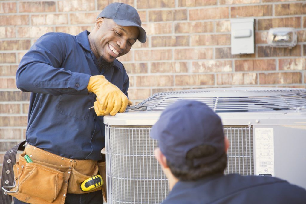 two handyman working on an hvac unit